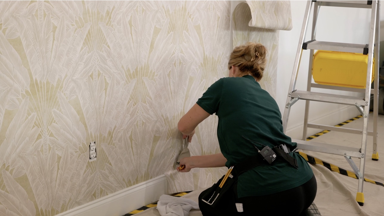Wallpaper installer working on a finished wall